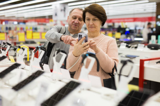 istock Happy mature spouses choose a mobile phone 1407894235