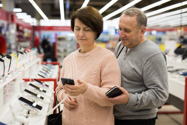 istock Happy mature spouses choose a mobile phone 1407894241