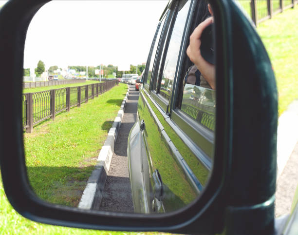 shooting through the suv rear view mirror - reportage photographer photographing street imagens e fotografias de stock