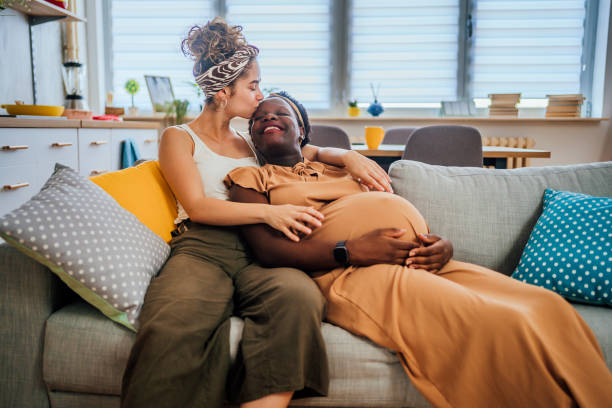Pregnant lesbian couple relaxing on sofa