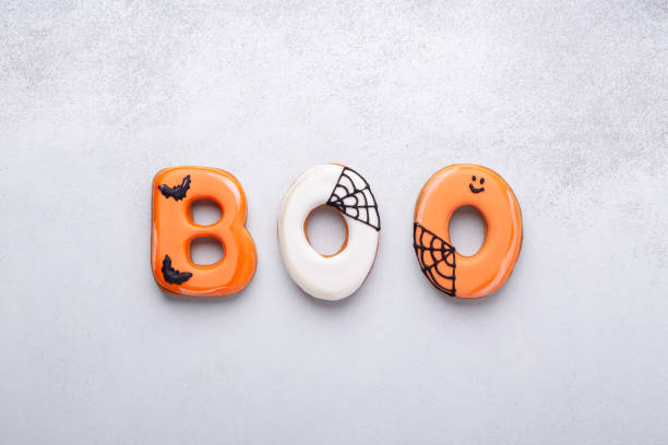 istock Text BOO from gingerbread cookies on white stone background. Halloween concept 1407897409