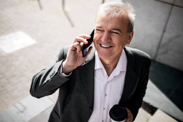 istock Senior businessman in city downtown using phone making conversation 1407899942