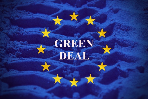 Wheel of a Tractor shape on the earth with the European flag as background with the sign green deal