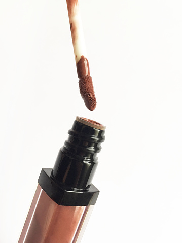 Lip gloss with brush on the white background