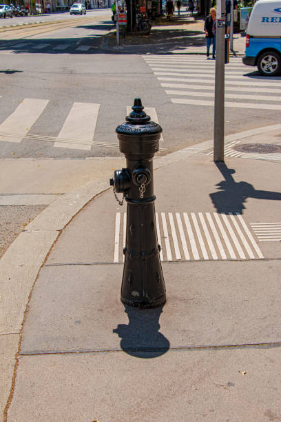 Retro hydrant column on a sunny day on the street in the old town of Vienna. Vienna, Austria - 06.13.2022: Retro hydrant column on a sunny day on the street in the old town of Vienna. old fashioned well hand pump stock pictures, royalty-free photos & images