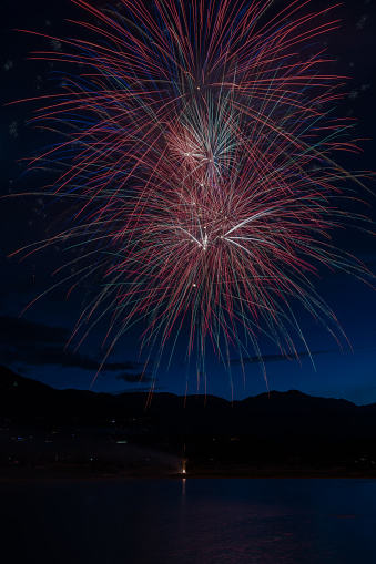 Fireworks display by lake in Colorado for July 4th Independence day celebration, Colorado Springs in western USA.