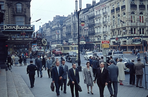 Brussels, Belgium, 1958. Street scene with pedestrians, cars, buildings and shops in Brussels during the World Exhibition