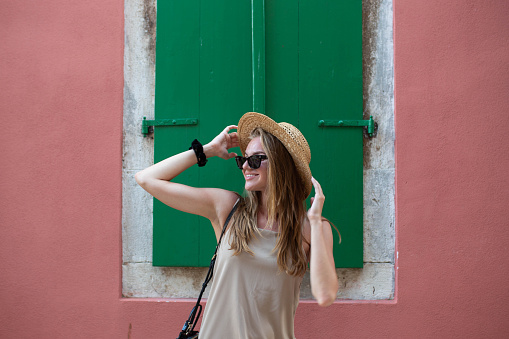 A girl with a hat is enjoying a summer day and exploring the city