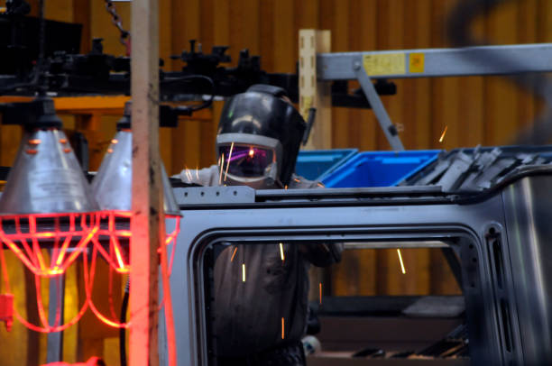 Iron worker welding an i beam on a high rise building