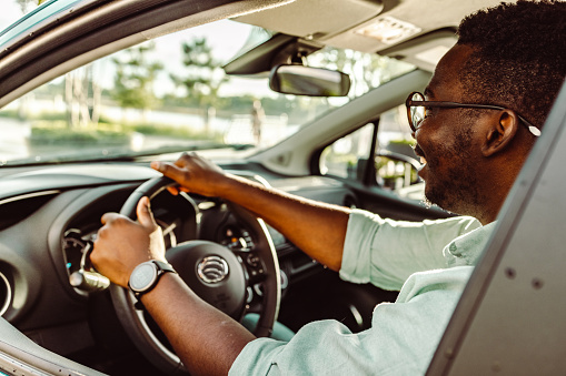 Rear view of an African-American man driving a car