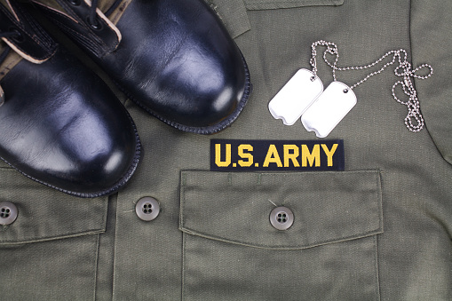 Uncle sam wants you - U.S. Army Branch Tape with dog tags and boots on olive green uniform background