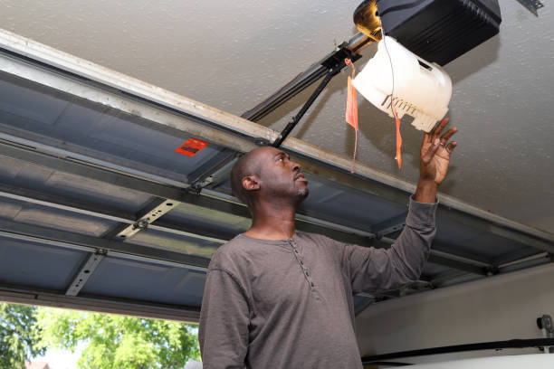 A portrait of a black African-American man changing a lightbulb in a overhead garage A portrait of a black African-American man changing a lightbulb in a overhead garage garage door opener photos stock pictures, royalty-free photos & images
