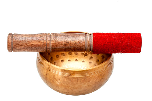 Tibetan copper singing bowl and wooden mallet with red fiber, objects for buddhism yoga isolated on white. Sound healing therapy meditation equipment for ayurveda spirituality religion, nobody.