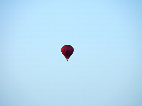 a balloon hanging in the sky. Red-stripped color.