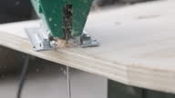 istock Sawdust flies off a metal blade as the jigsaw cuts into a sheet plywood workpiece. Carpenter cuts off the edge of a plywood plank. Jigsaw cuts into a piece of plywood off. 1407932773
