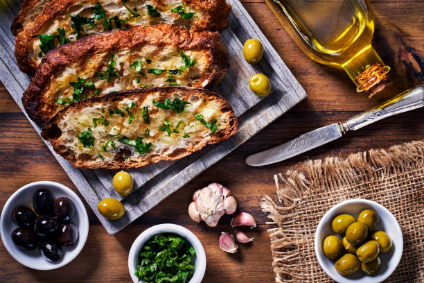 istock Snack or appetizer of garlic basil and olive oil bruschetta on table in a rustic kitchen 1407935653