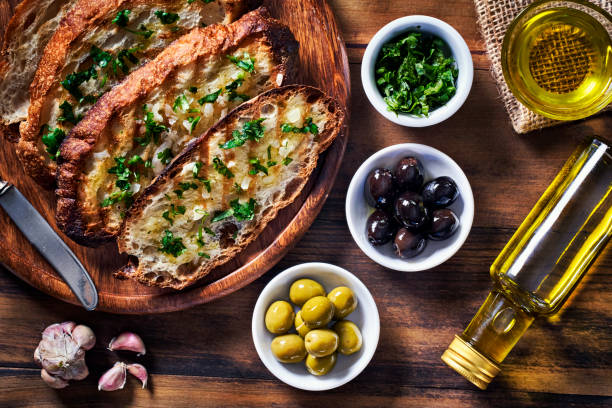 istock Snack or appetizer of garlic basil and olive oil bruschetta on table in a rustic kitchen 1407935840