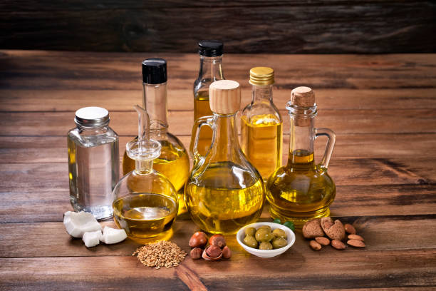 istock Assorted healthy vegetable oil bottle collection on wooden table in a old fashioned kitchen with low key illumination 1407936398
