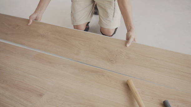 uomo che installa un nuovo pavimento in legno lamellare in legno, miglioramento della casa, concetto di progetto di ristrutturazione della casa - make over series foto e immagini stock