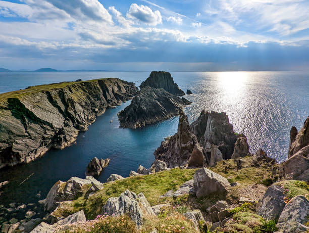 irische landschaftsszene mit sonnenlicht, das durch die wolken über den klippen und dem ozean von malin head in irland scheint - ireland landscape stock-fotos und bilder