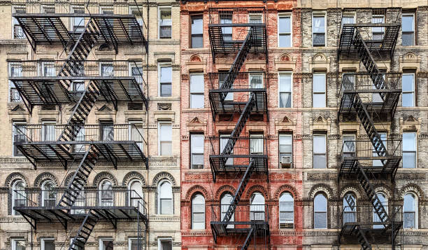 Exterior view of New York City style architecture apartment building with windows and fire escapes stock photo
