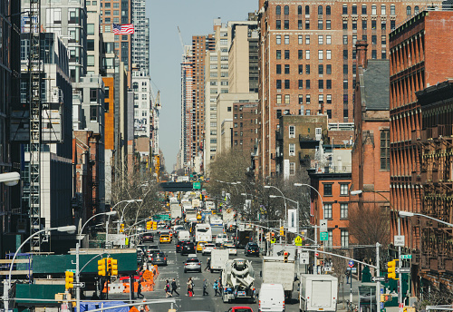 Overhead view of a busy street scene with people and traffic traveling through Manhattan in New York City NYC