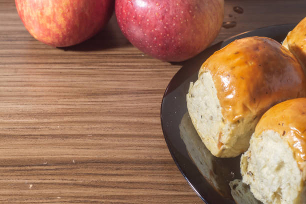 istock Breads and apples on a wooden tablet with copy space and soft light 1407942115