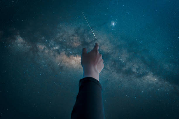 hand pointing or touching the starry sky with Milky Way and stars	 background stock photo