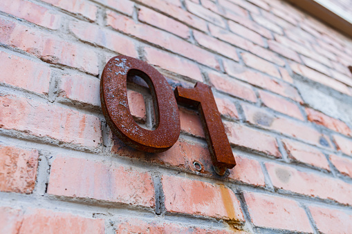 01 House number hanging on the wall, House number on the brick wall of a building