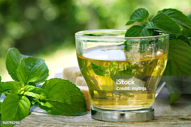 A Glass Of Mint Tea On A Table Covered In Mint Leaves Stock Photo - Download Image Now