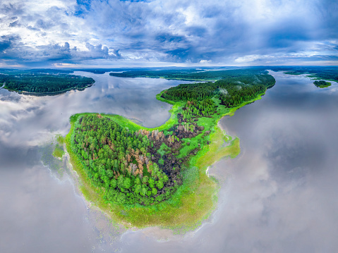 Big lake with green shores in bright sun light, aerial landscape. Recreation concept. Sky reflection. Ecology in Europe. Aerial view