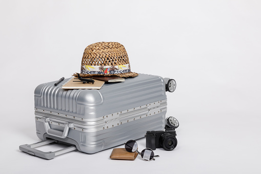 Travel Baggage with passport, camera, hat, wallet, airplane toy isolated on white background with copy space, Travel concept background