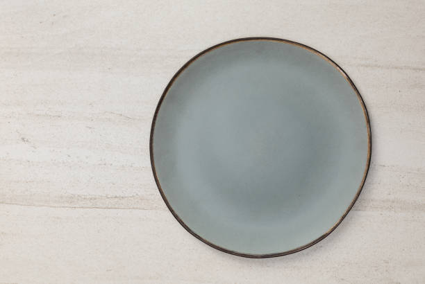 istock Empty blank green ceramic round plate or dish on white stone blackground with copy space, Top view of traditional handcrafted kitchenware concept 1407955055