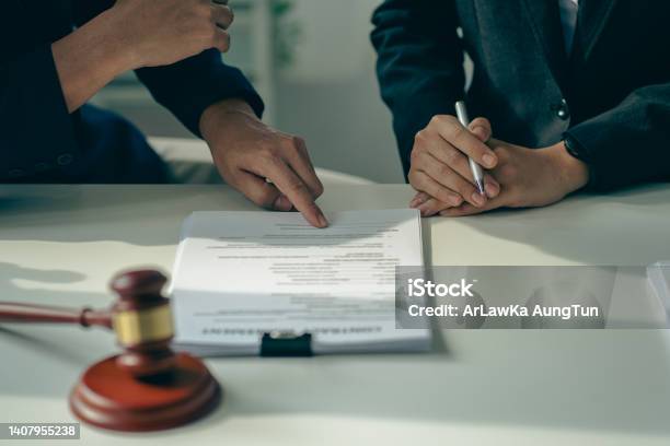 Male Businessman And Lawyer Consulting With The Client Team On Law Discussing And Signing Office Contract With Judges Scale And Hammer On Legal Services Concept Table Stock Photo - Download Image Now