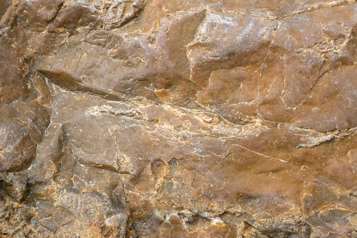 The texture of the surface of the stone closeup. Abstract brown background.