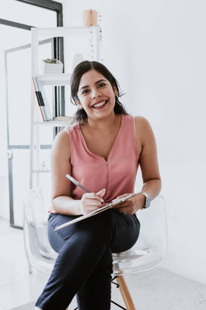 hispanic young woman psychologist holding clipboard at psychology center in Mexico Latin America hispanic young woman psychologist holding clipboard at psychology center in Mexico Latin America physical therapist stock pictures, royalty-free photos & images