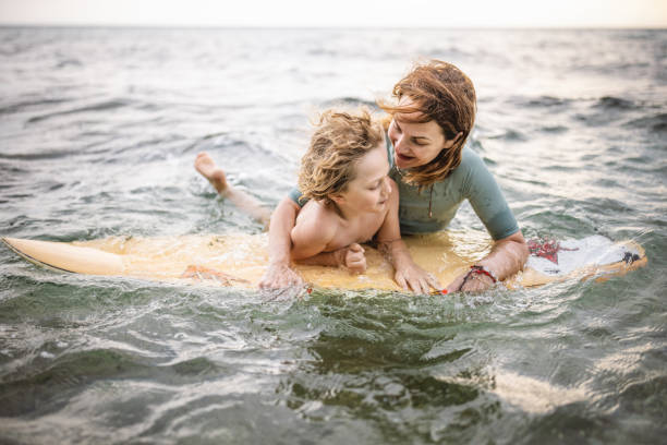 istock Mother helping son surfing on board 1407956479