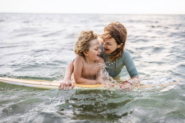 istock Mother helping son surfing on board 1407958191