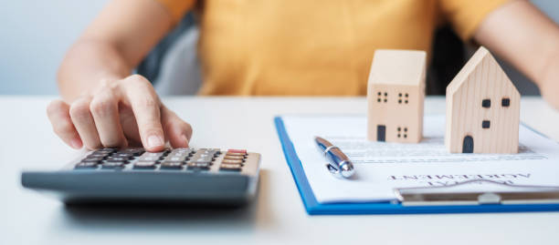 istock Woman using calculator during signing home contract documents. Contract agreement, real estate,  buy and sale and insurance concepts 1407961985