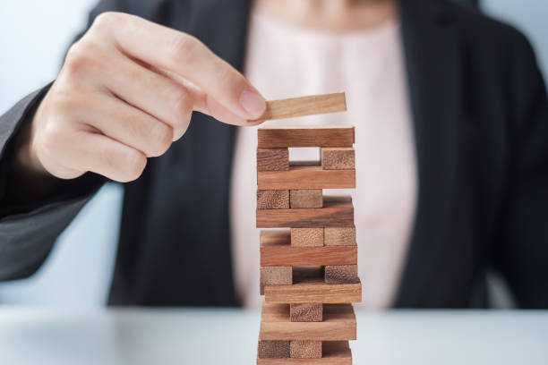 empresária colocando ou puxando bloco de madeira na torre. planejamento de negócios, gestão de riscos, soluções e conceitos de estratégia - balance - fotografias e filmes do acervo