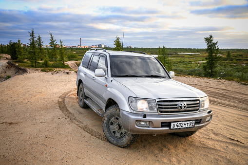 Novyy Urengoy, Russia - July 10, 2021: Offroad car Toyota Land Cruiser 100 on a gravel road.