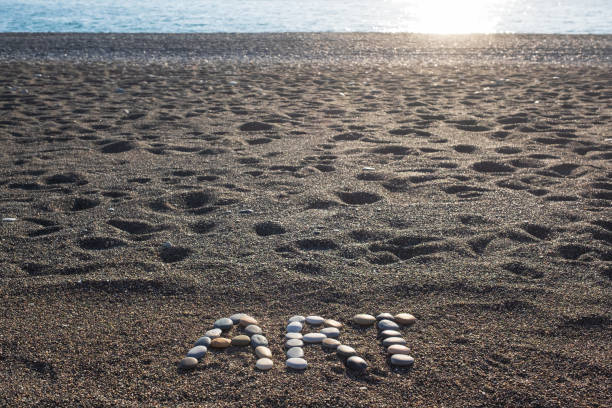 istock Word art made from stones on sandy beach 1407969018