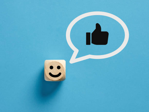 istock Happy face icon on a wooden cube with like or thumb up gesture in a speech bubble. 1407972813