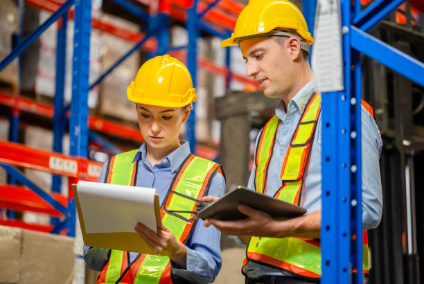 istock Manager and supervisor taking inventory in warehouse, Female foreperson making plans with warehousemen, Workers working in warehouse 1407973059