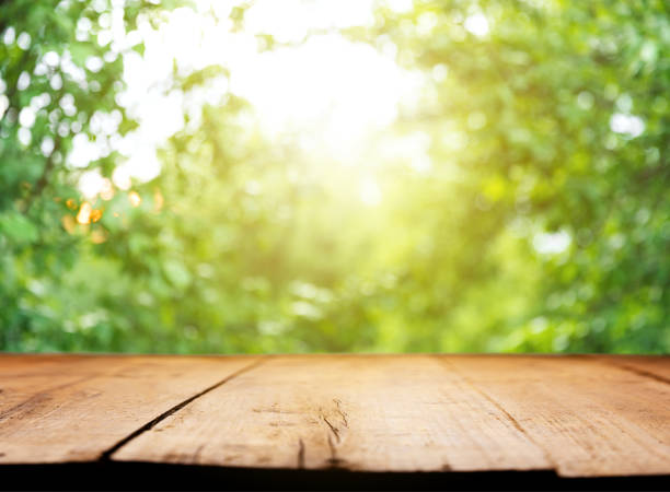 istock Empty blank wooden plank, deck or table with defocused green trees background 1407973199