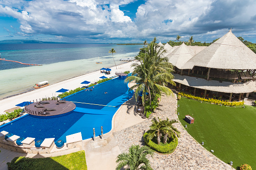 Panglao, Bohol, Philippines - Nov 2021: The Bellevue Resort facing Doljo Beach on the north face of Panglao facing the Bohol Sea. The mountains in Maribojoc visible in the background.