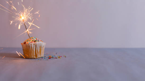 Delicious muffin and burning sparkler decorating stock photo
