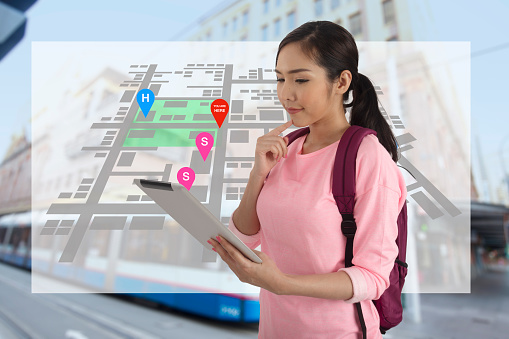 Asian tourist woman use gps navigation application on digital tablet to search place to visit.