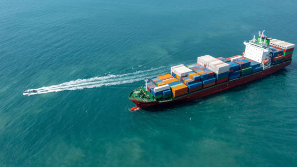 istock Aerial side view of cargo ship carrying container and running with pilot boat for export  goods  from  cargo yard port to custom ocean concept technology transportation , customs clearance. 1407975773