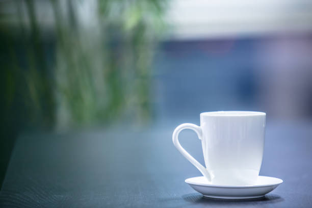 Closeup of white coffee cup on table in empty corporate conference room